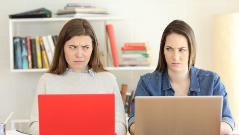 Two female college roommates glaring at each other.