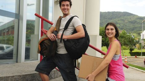 Young sister helping her brother move into freshman year dorm on college move-in day