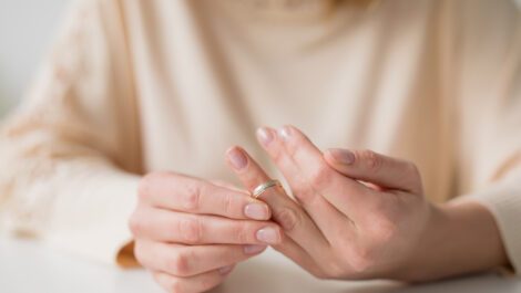 A woman taking off her wedding ring.