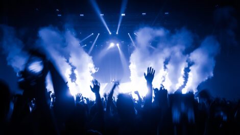 People waving their hands in the air at a concert.