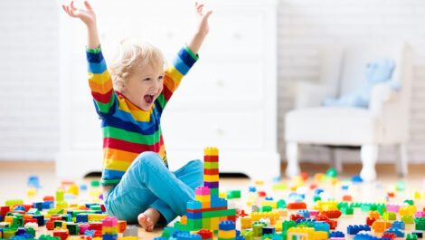 A young child playing with legos in a playroom.