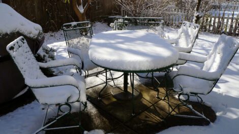 Outdoor patio furniture covered in snow.