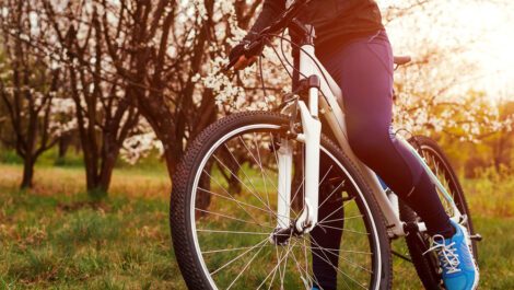 A person riding a bike in a grass field.
