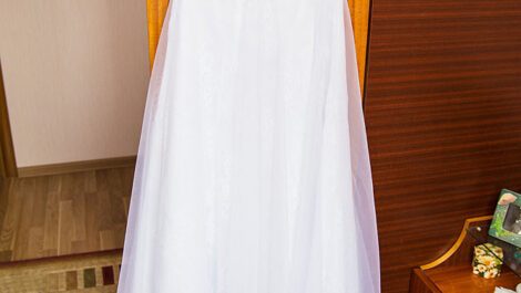 A wedding dress hanging on a wall.