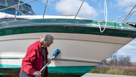A man cleaning the outside of a boat.