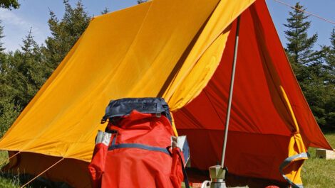 A tent and camping equipment in the forest.