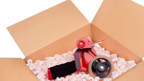 A box full of protective packaging peanuts and a tape dispenser.
