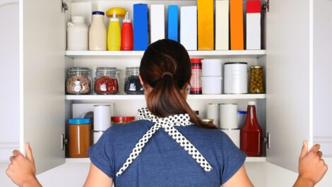A woman looking into an organized pantry.