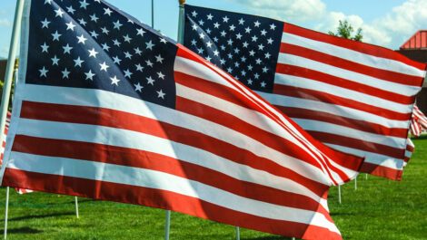 Two American flags waving in the wind.