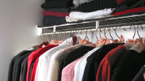 An organized closet filled with clothes.