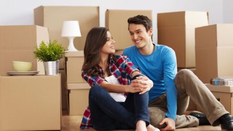 Young couple smiling in their new house.