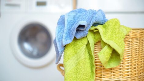 Two towels hanging out of a laundry basket.