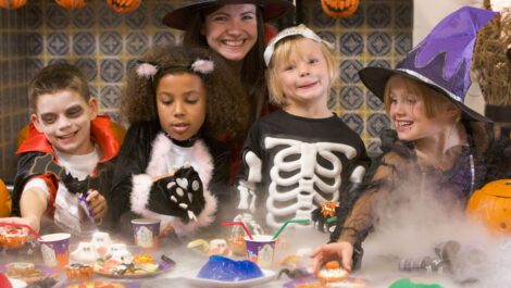 Four children and one adult celebrating Halloween.