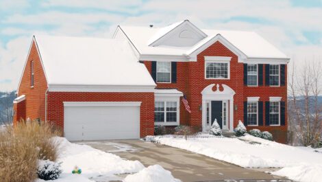 Red brick house covered in snow.