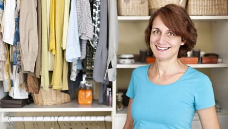 Woman smiling inside a closet.