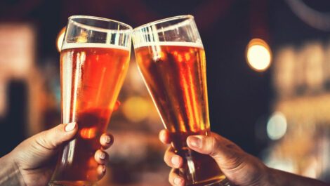 Two people toasting with beer glasses.