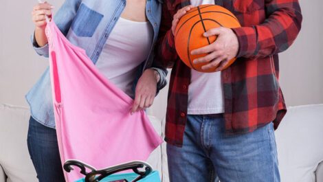Young adult couple moving items from a box.