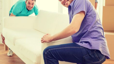 Two college students moving a couch.