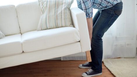 Man lifting a couch.