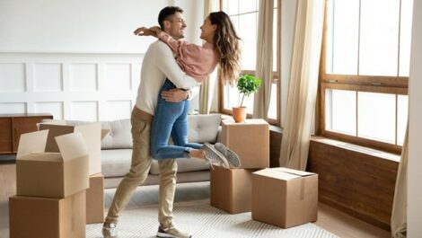 A man and woman dancing among moving boxes.